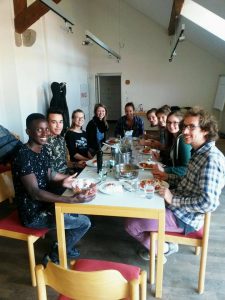 Gruppe junger Menschen sitzt um den Essenstisch
