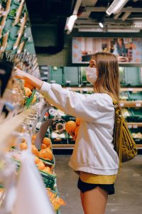 Mädchen im Supermarkt mit Maske